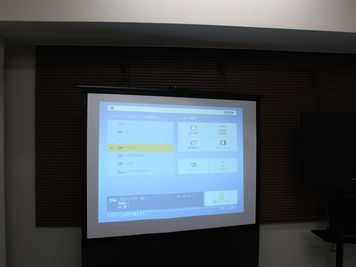 プロジェクターを利用するとスクリーンも合わせて利用できます。 - 池袋レンタル会議室.COM レンタル会議室の設備の写真