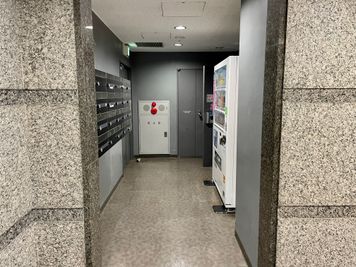 【1階エレベーターの奥に自動販売機があります】 - 【閉店】TIME SHARING 浜松町コスモ金杉橋ビル 2階　貸し会議室の入口の写真