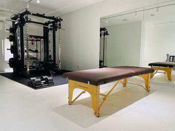 ４５平米の広い空間で、パーソナルストレッチ、マッサージ等ご利用いただけます。 - S&FITNESS 【池袋最大級】白を基調とした内装、大型ミラーが特徴のレンタルジムの設備の写真