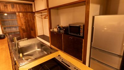 冷蔵庫、オーブンレンジ、IHコンロ、ケトル、各種食器、調理器具の揃ったアイランドキッチンスペースです。 - 湯小屋 霞-kasumi- 24時間入室可能のキッチン浴室付きのレンタルスペースです。の室内の写真