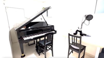 二人掛けソファーと、テーブル、背もたれ付きピアノ椅子2脚、動画撮影用マイク - STUDIO KID～ピアノ室～ グランドピアノのある防音室の室内の写真