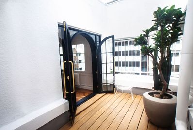 Aoyama loft apartment ビルの屋上に佇む、白壁と植物に包まれた開放的なスタジオの室内の写真